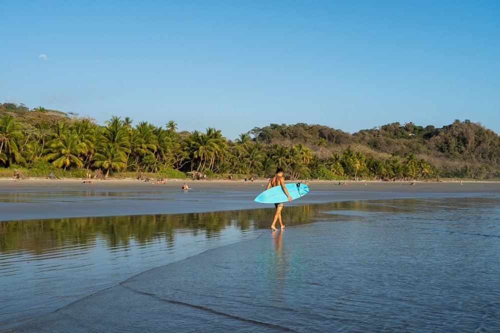 guy walking with surf board in Costa Rica