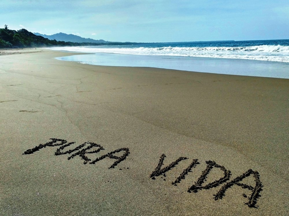 Pura vida written in sand