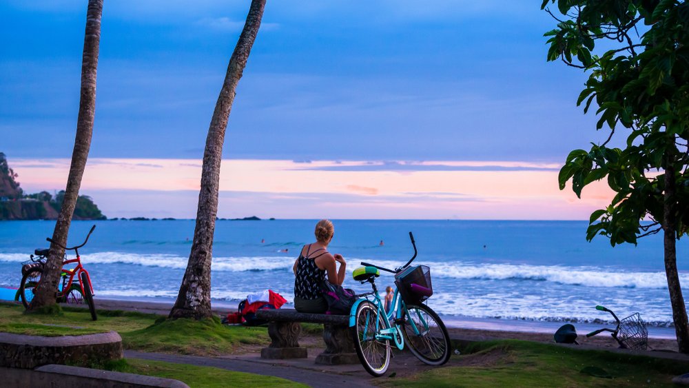 woman sitting next to her bike looking at the water