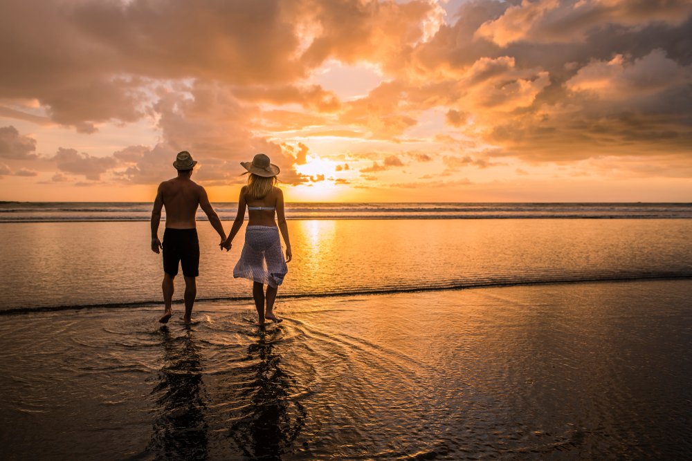 Couple walking hand in had at sunset