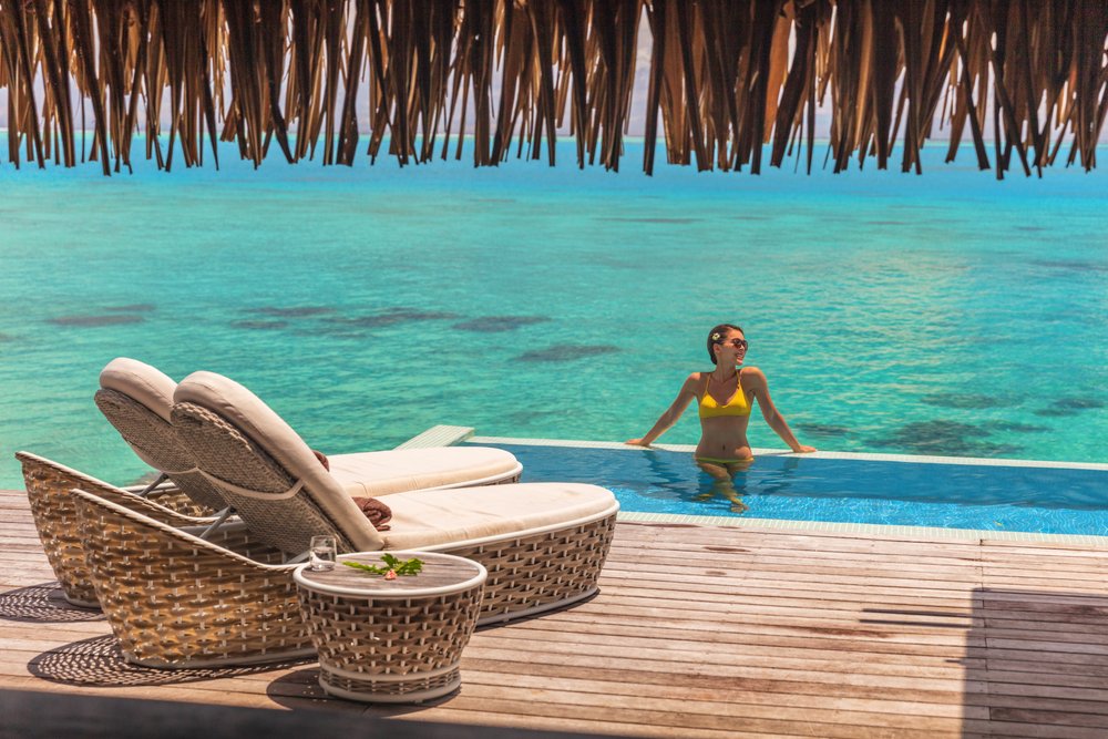 girl in yellow bikini in pool in overwater bungalow in Mexico